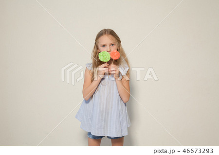 little girl eating sweet candy lollipop on a stick little girl eating sweet candy lollipop on a stick 46673293