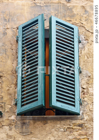 Window with wooden shutters of old house in Siena 46678895