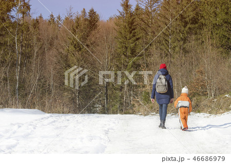 Mother withlittle son walking along snow road 46686979