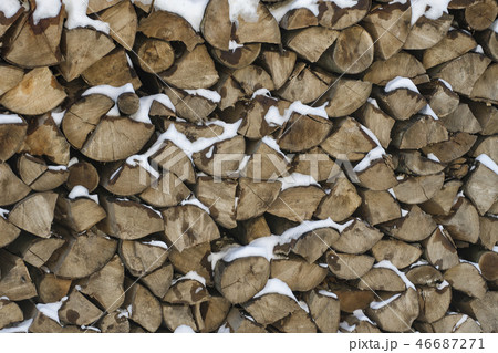 Chopped firewood on a stack in snow. Front view. Chopped firewood on a stack in snow. Front view. 46687271