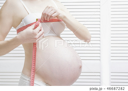Pregnant woman measures breast volume Pregnant woman measures breast volume 46687282