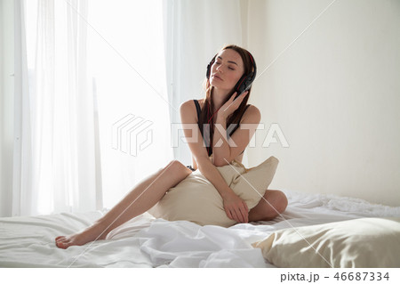 beautiful woman in underwear sitting on a bed with a pillow bedroom beautiful woman in underwear sitting on a bed with a pillow bedroom 46687334