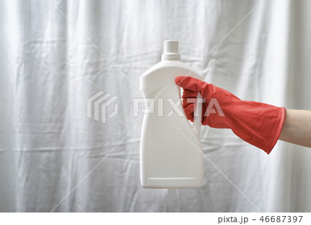 Gloved hand holding a big white bottle. Washing Gloved hand holding a big white bottle. Washing 46687397