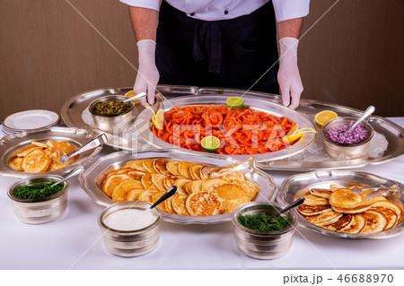 A fish table with pancakes and red fish, sour crea A fish table with pancakes and red fish, sour crea 46688970