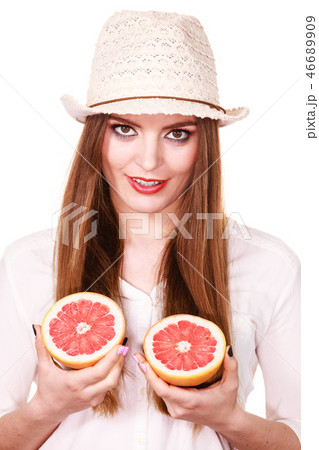 Woman holds two halfs of grapefruit citrus fruit in hands Woman holds two halfs of grapefruit citrus fruit in hands 46689909
