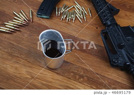 rifle and cup of coffee on wooden table rifle and cup of coffee on wooden table 46695179