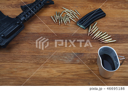 rifle and cup of coffee on wooden table rifle and cup of coffee on wooden table 46695186