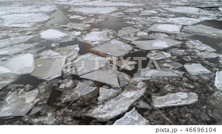 broken ice on a winter river with sunset sky reflection 46696104