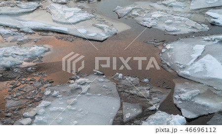 broken ice on a winter river with sunset sky reflection 46696112