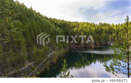 abandoned quarry with steep shores overgrown with  46698875