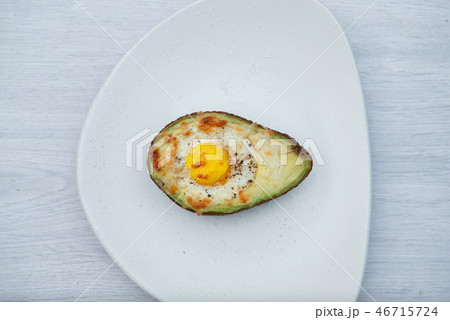 One egg baked in avocado on wooden table 46715724
