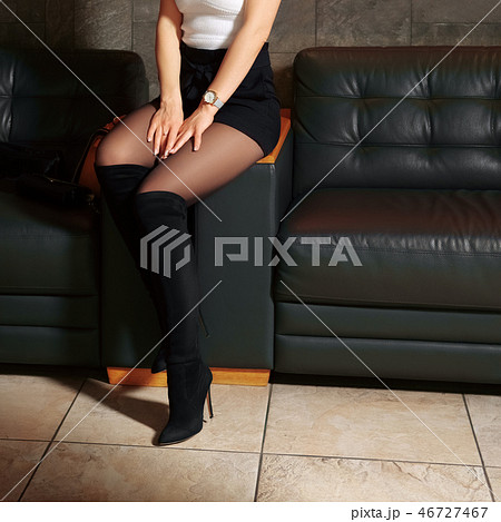 Female legs in pantyhose on leather sofa Female legs in pantyhose on leather sofa 46727467