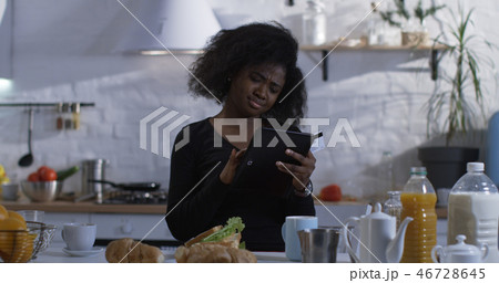 Woman using her tablet in the kitchen 46728645
