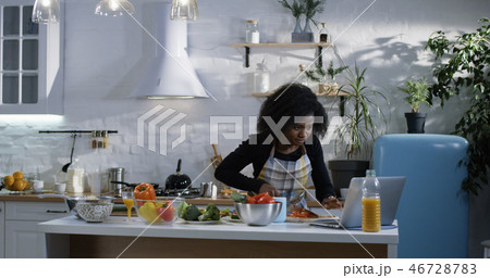 Young woman preparing food in the kitchen Young woman preparing food in the kitchen 46728783