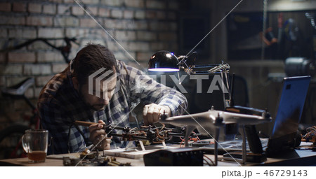 Man repairing a drone in a garage Man repairing a drone in a garage 46729143