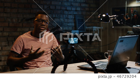 Young man talking on camera in a garage Young man talking on camera in a garage 46729204