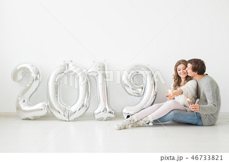 New 2019 Year is coming concept - Romantic young man and woman with silver colored numbers on white 46733821