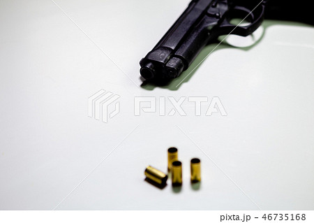 Handgun with 9mm shell casings on white table Handgun with 9mm shell casings on white table 46735168