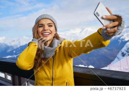 Young woman taking a selfie in winter holiday in mountain.Young Young woman taking a selfie in winter holiday in mountain.Young 46737923