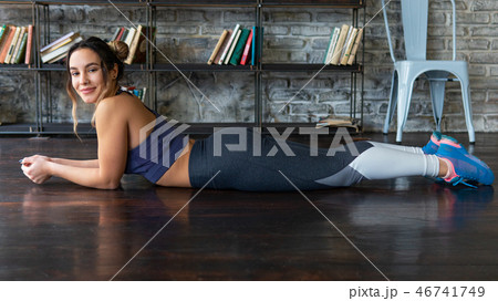 Young happy relaxed fitness woman lying on floor Young happy relaxed fitness woman lying on floor 46741749