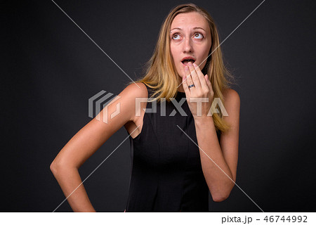 Young beautiful businesswoman with straight blond hair against g 46744992