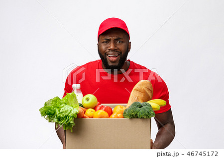 Young african american man holding grocery box in hands with shocking face. Isolated over Grey 46745172