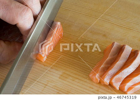 サーモンの刺身を引く 46745319