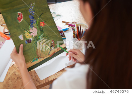 Painte holding pencil and picture of lovely flowers. Painte holding pencil and picture of lovely flowers. 46749076