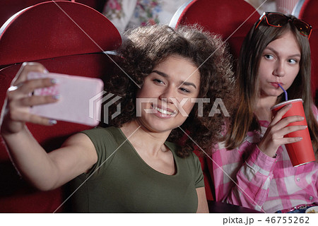 Brunette taking selfie in cinema hall. Brunette taking selfie in cinema hall. 46755262