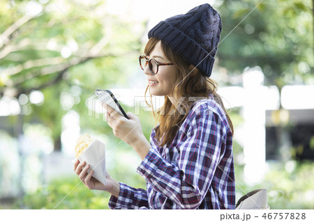 公園でスマホを見る女性　 46757828