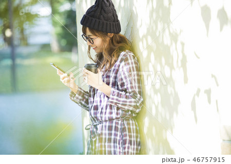 公園でスマホを見る女性　 46757915