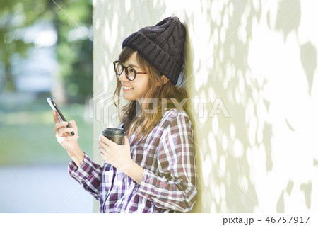 公園でスマホを見る女性 公園でスマホを見る女性 46757917