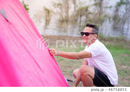 an Asian man in white t shirt setting pink tent at an Asian man in white t shirt setting pink tent at 46758855