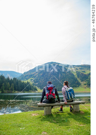 young couple of backpackers near the lake in mountains 46764239