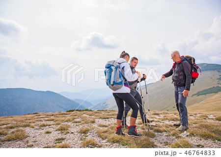 An elderly man giving a tour for a young group of people An elderly man giving a tour for a young group of people 46764833
