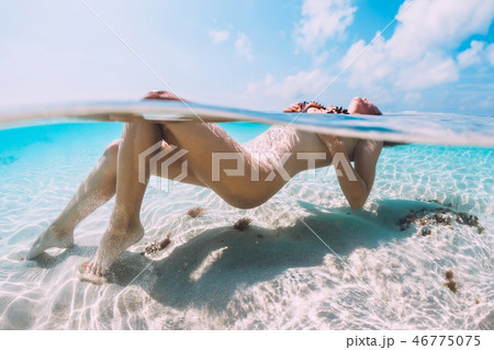 Nude woman floating and relax in tropical blue sea 46775075