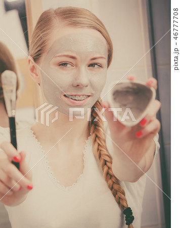 Girl holding clay mud mask and brush. Skin care. 46777708
