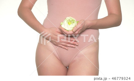 Close-up of a pregnant woman holding a white lotus flower next to her belly Close-up of a pregnant woman holding a white lotus flower next to her belly 46779324