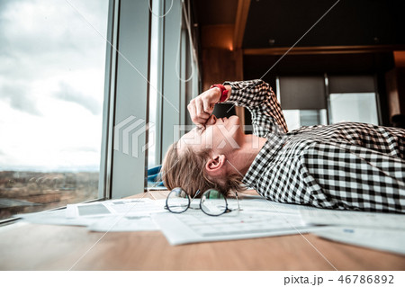Young man lying on his workplace on pause 46786892