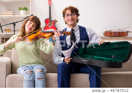 Young woman during music lesson with male teacher Young woman during music lesson with male teacher 46787012
