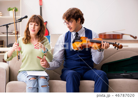Young woman during music lesson with male teacher 46787020