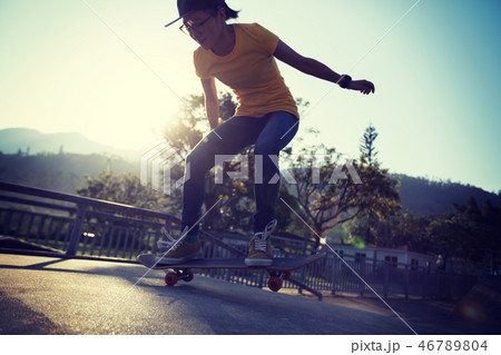 Skateboarder doing ollie at skatepark ramp 46789804