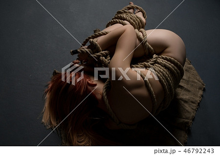 Girl tied up in shibari style on the floor shot Girl tied up in shibari style on the floor shot 46792243