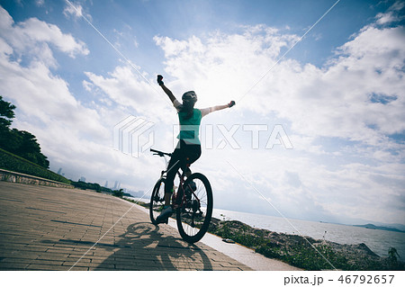Hands free cycling woman riding Bike seaside Hands free cycling woman riding Bike seaside 46792657