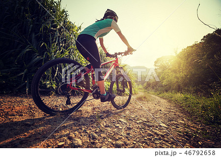 Woman cyclist riding mountain bike on rocky trail  46792658