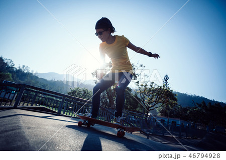Skateboarder doing ollie at skatepark ramp 46794928