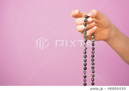 Woman, lit hand close up, counts Malas, strands of gemstones beads used for keeping count during Woman, lit hand close up, counts Malas, strands of gemstones beads used for keeping count during 46800430