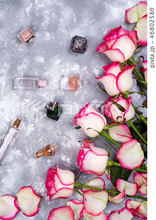 Floral frame composition with roses and many different perfume bottles on stone background. Flat lay Floral frame composition with roses and many different perfume bottles on stone background. Flat lay 46802580