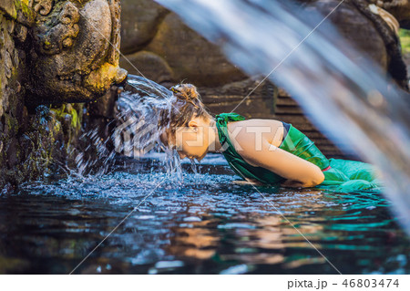 Woman in holy spring water temple in bali. The temple compound consists of a petirtaan or bathing 46803474