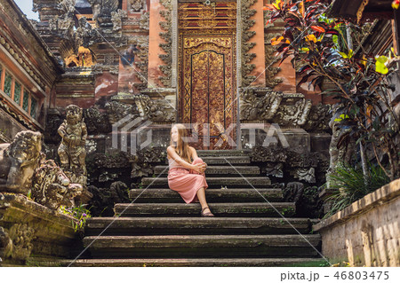 Young woman traveler in the background of Pura Taman Kemuda Saraswati Temple in Ubud, Bali island 46803475